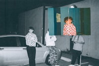 a group of people standing in front of a car